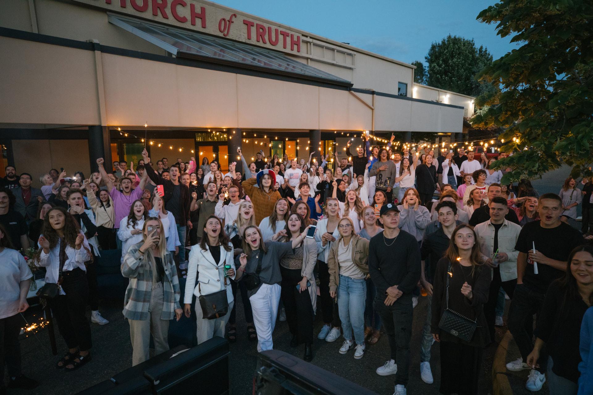 Crowd worshiping outside the Church of Truth building in Vancouver, WA at an evening event