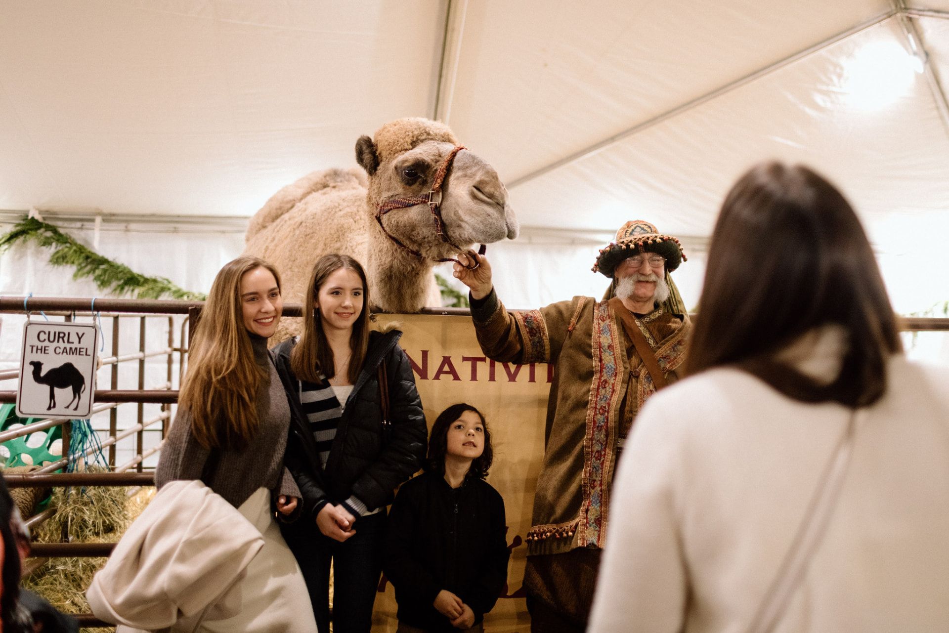 Guests posing with Curly the camel in the Night in Bethlehem animal tent